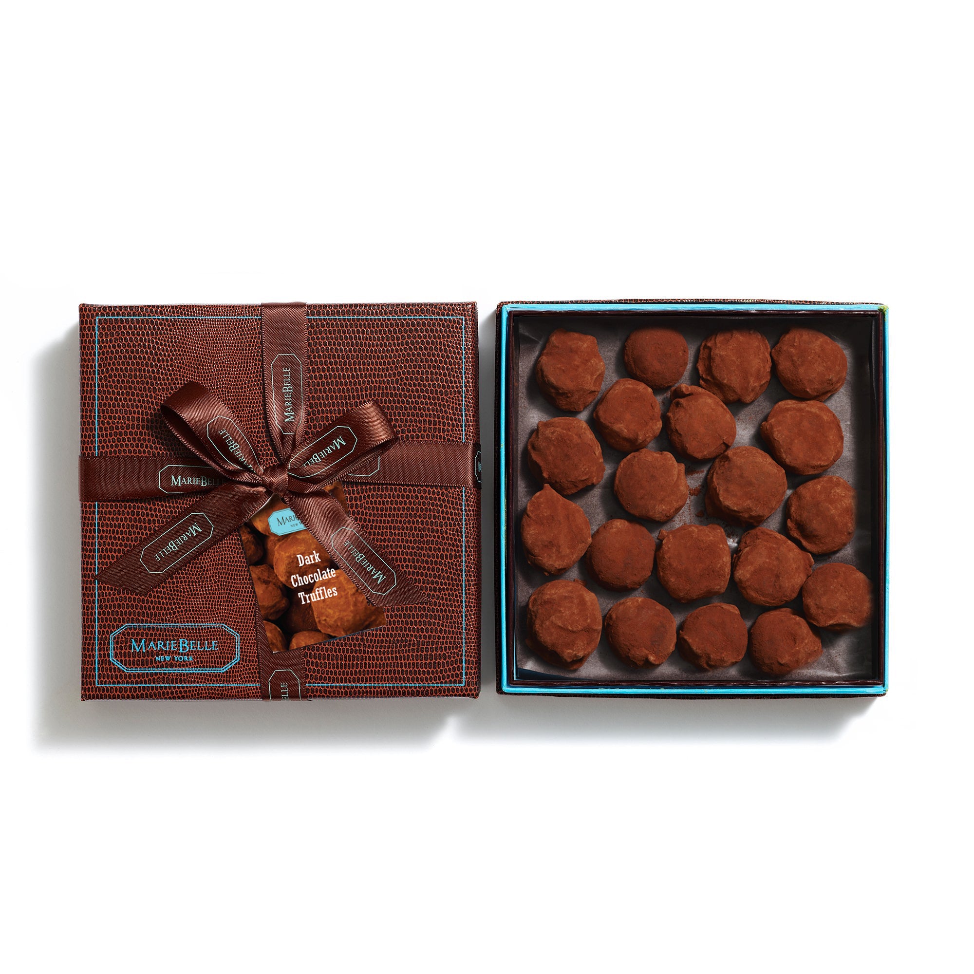 Open brown gift box with a bow containing chocolate truffles on a white background