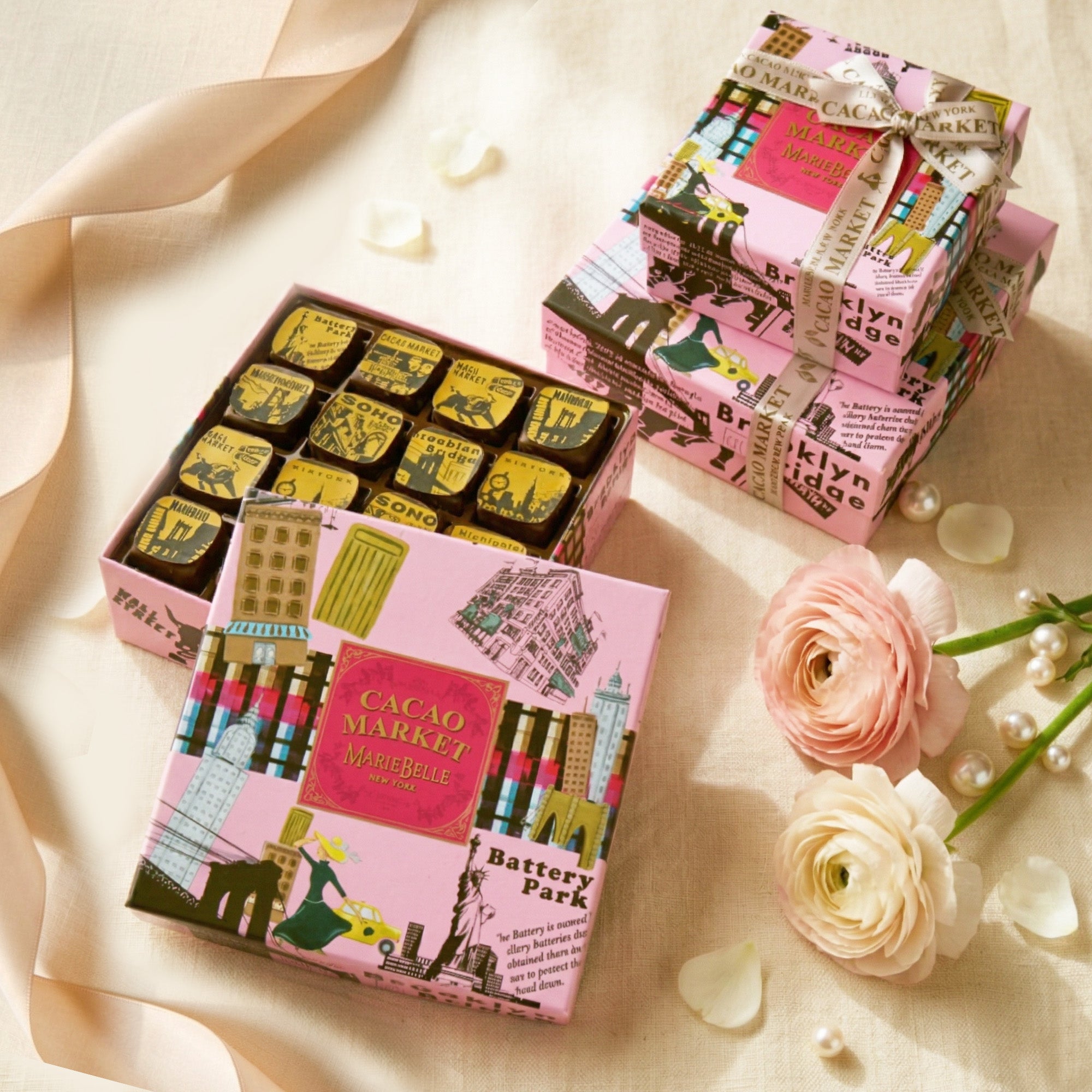 Cacao Market chocolate boxes with decorative packaging on a light background with flowers.