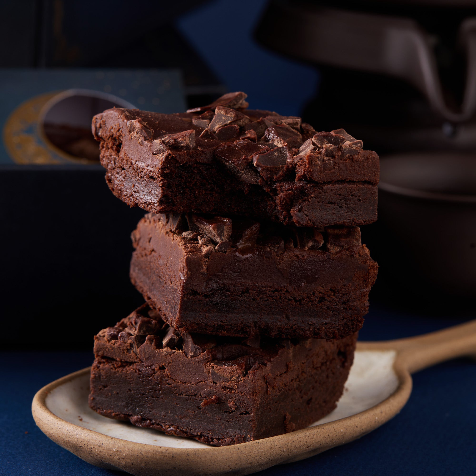 Stack of chocolate brownies on a plate with a blurred background