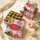 Cacao Market chocolate boxes with decorative packaging on a light background with flowers.