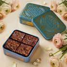 Decorative brownie tins with brownies and flowers on a light background