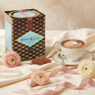 Mariebelle hot chocolate with a cup of hot chocolate, flowers, and pearls on a soft background